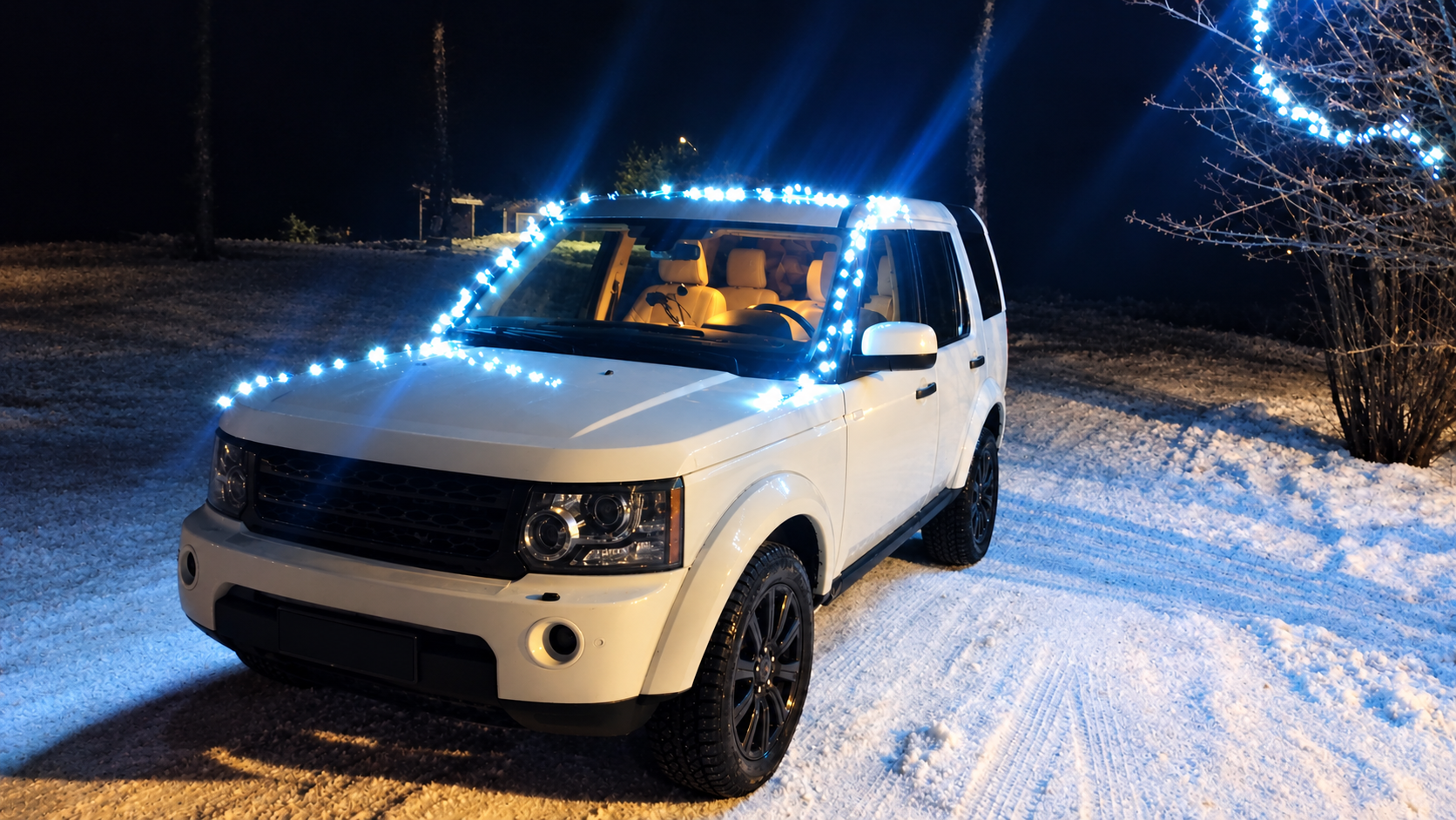 Land Rover with blue lights waiting in the snow at night for a private airport transfer in Swedish Lapland