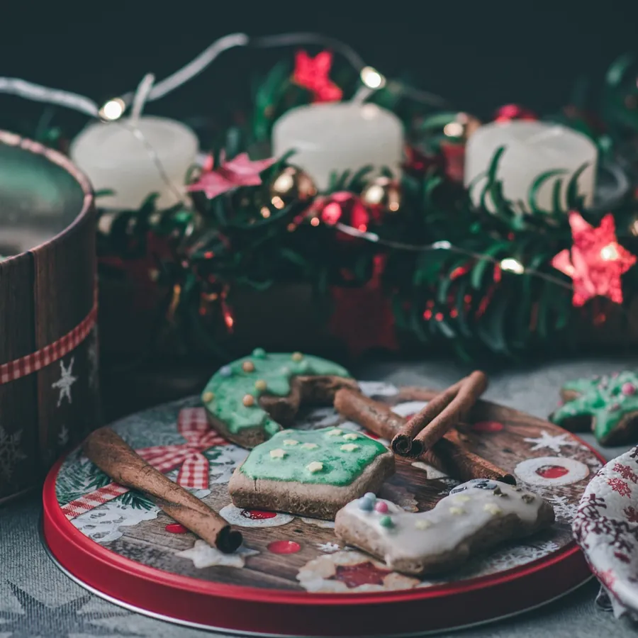 Christmas gingerbread cookies with green icing, cinnamon sticks and advent candles